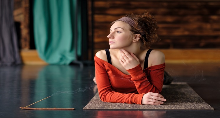 Tired young curly woman relax after training on mat.